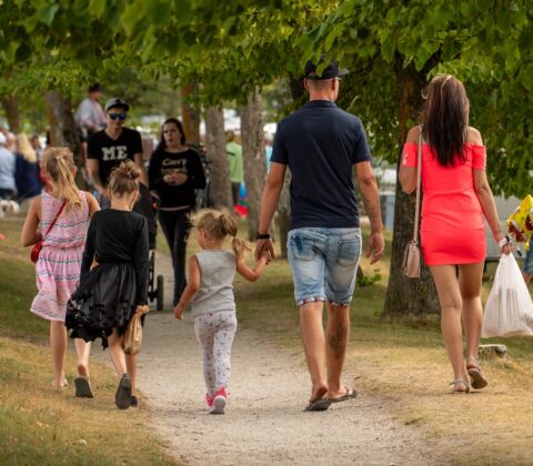 Family walking on a path in a park.