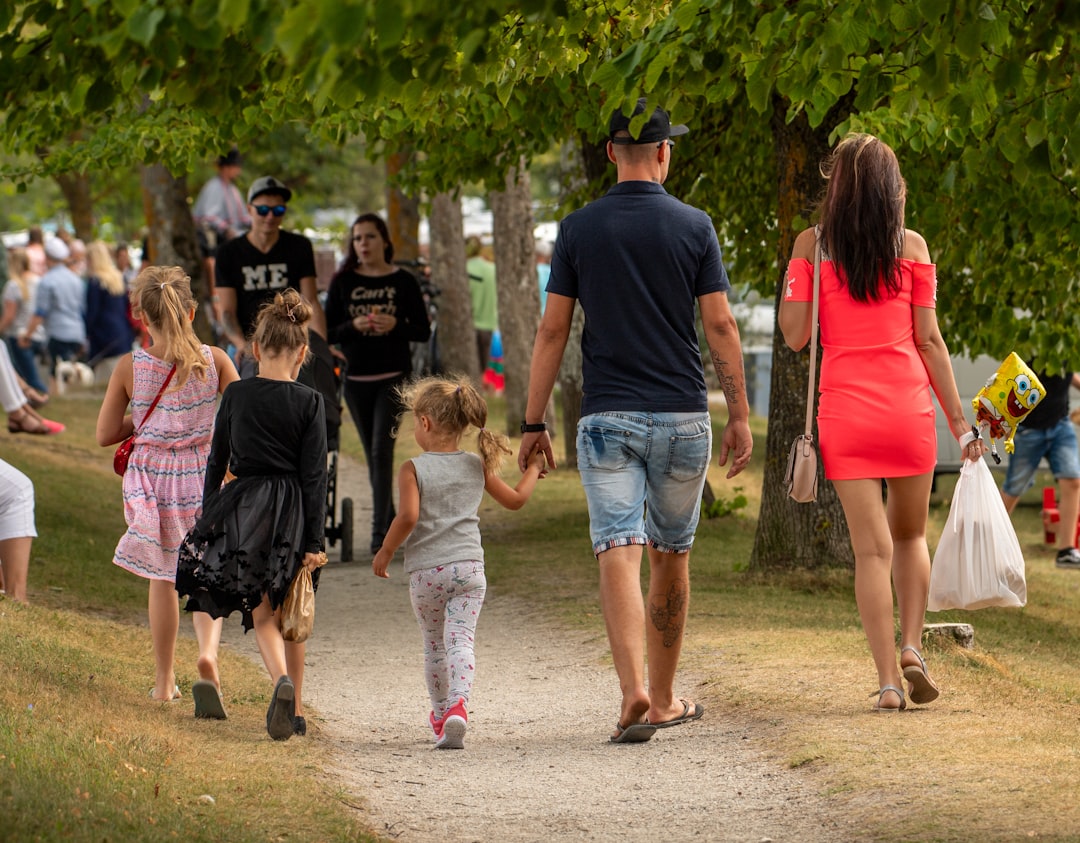Family walking on a path in a park.
