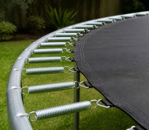 Trampoline in een tuin met zicht op springmat en frame tijdens het onderhoud