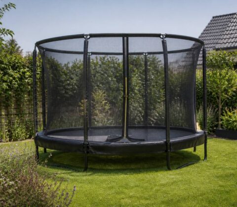 Ronde trampoline met randkussen en veiligheidsnet in een Nederlandse achtertuin