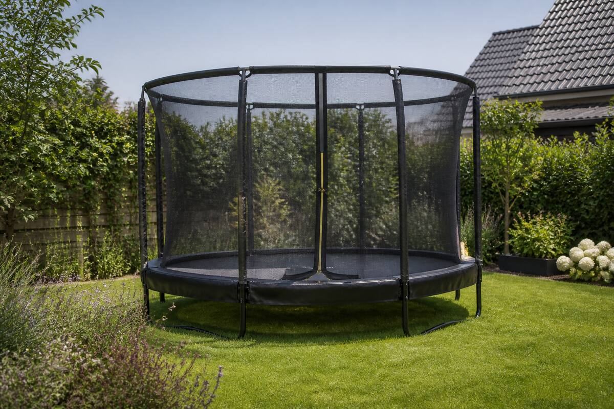 Ronde trampoline met randkussen en veiligheidsnet in een Nederlandse achtertuin