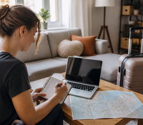 Persoon gebruikt een checklist op de laptop bij het vergelijken van vakanties